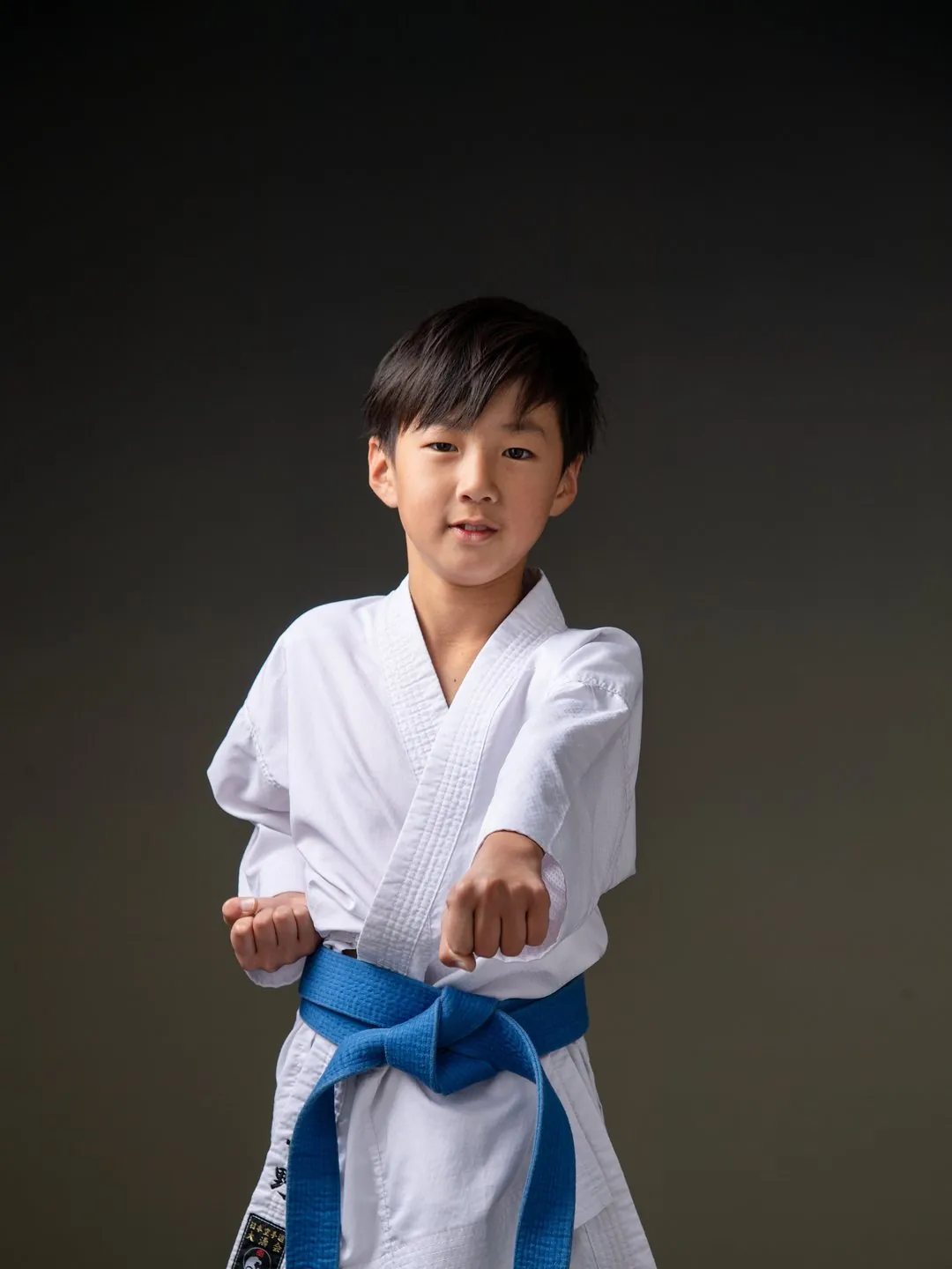 道着に青帯で構えるハーフ成人式の男の子