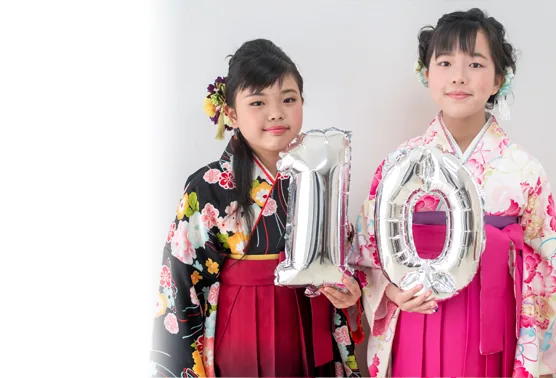 「10」のバルーンを持つ袴姿のふたりの女の子