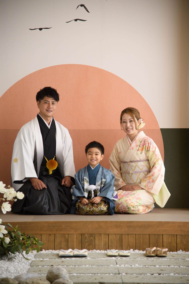 家族3人が和装で並んで座っている写真。ご家族揃って和装での撮影です。お父様の凛々しい袴姿、お母様の華やかな着物姿、そして主役のお子様の可愛らしい晴れ着姿。