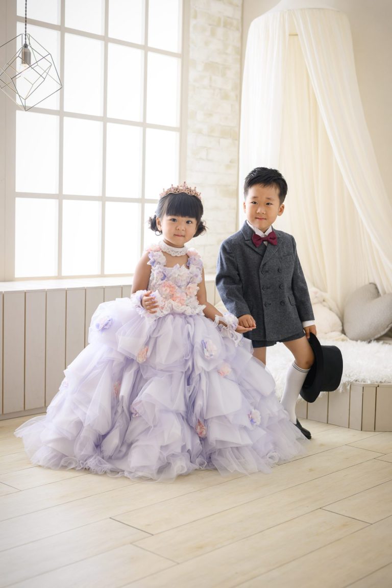 女の子と男の子が手をつないで立っている写真。仲良く手をつなぎ、並んで立つ二人の姿。お兄ちゃんの凛々しい表情と、妹の嬉しそうな笑顔が印象的です。