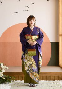 着物姿で微笑む女性の写真。紫の振袖は、お客様の落ち着いた雰囲気にぴったり。
