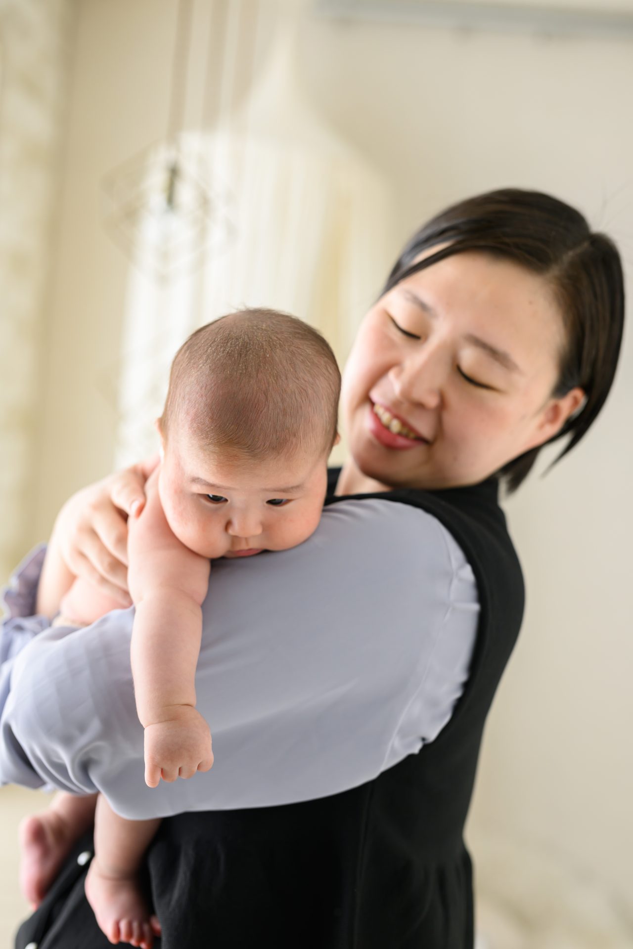 赤ちゃんを抱っこする優しい表情のお母様