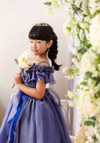 大人っぽい落ち着いた色のドレスを着てほほ笑む女の子
