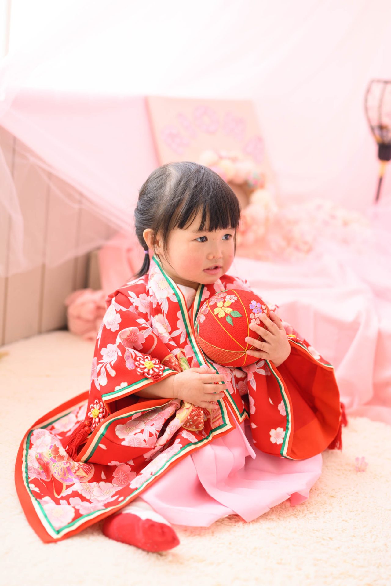 十二単風の着物を羽織り毬で遊ぶ女の子