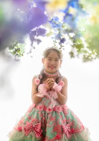フラワーカーテンの下でほほ笑む女の子