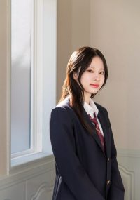 制服姿で窓辺に立つ女の子