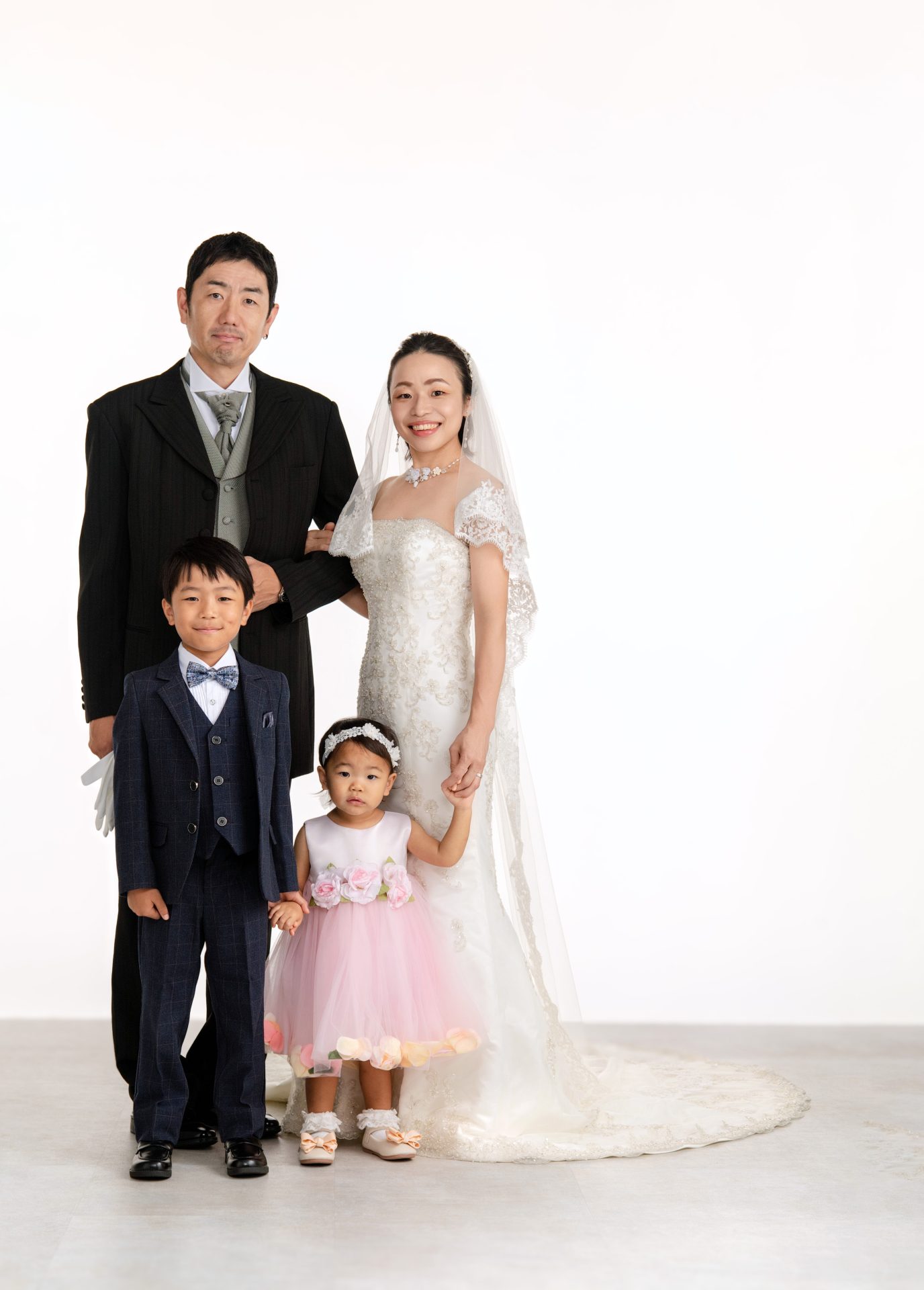 タキシードと上でドレスを纏った両親と二人のお子様