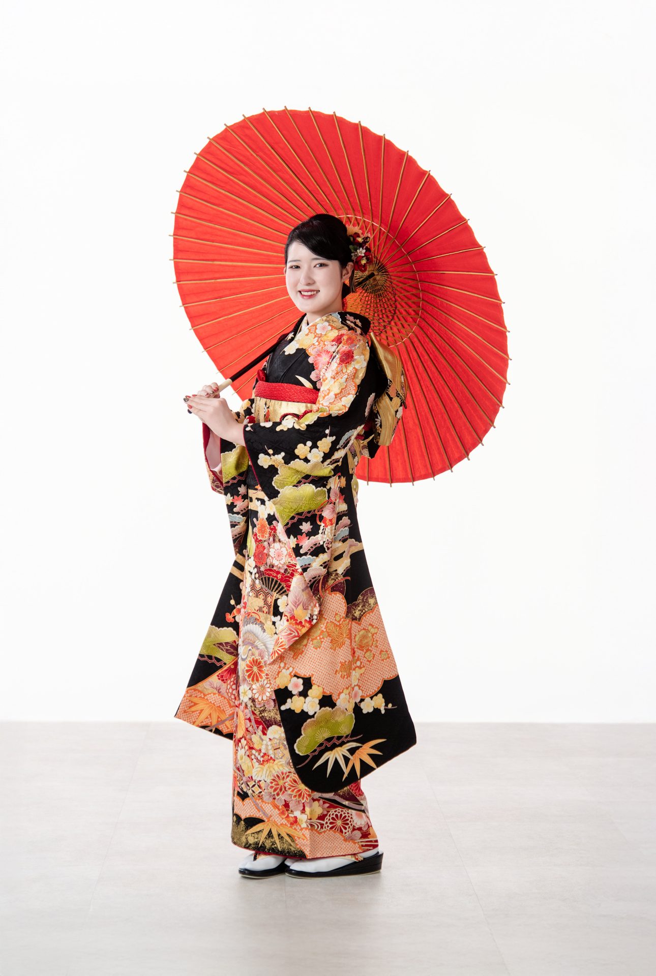 赤い和傘に黒地の振袖が良く映える