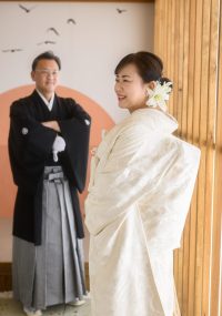 白無垢の新婦様を奥で見つめるご主人の微笑み